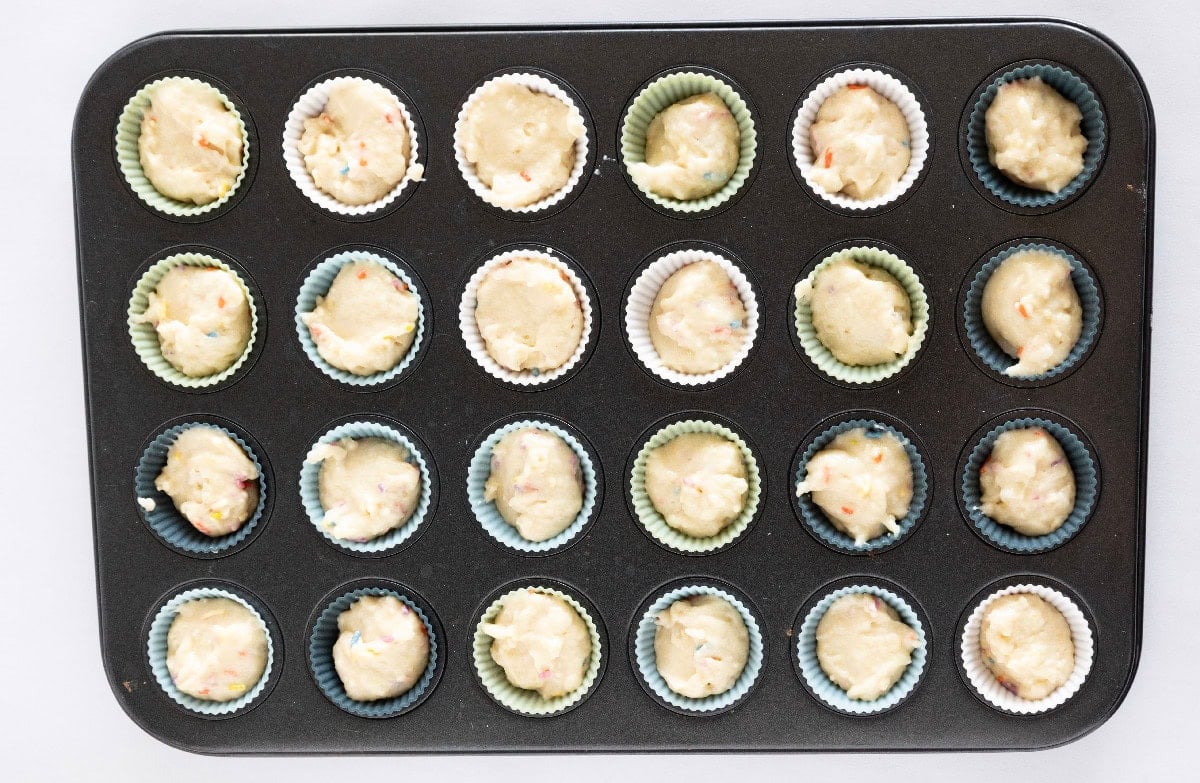 Mini muffin pan filled with birthday cake mini muffin batter before baking.