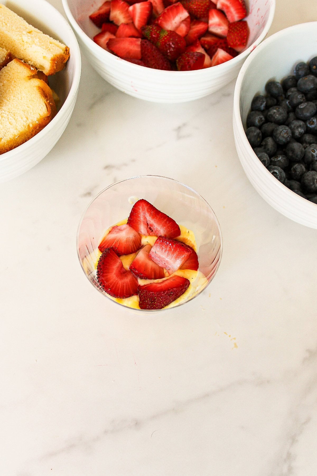 Fresh sliced strawberries layered over vanilla pudding in a patriotic parfait cup.