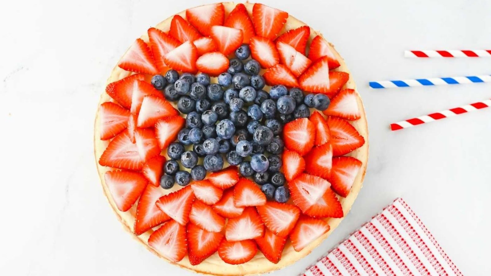 Patriotic cheesecake decorated with red and blue berries on top.