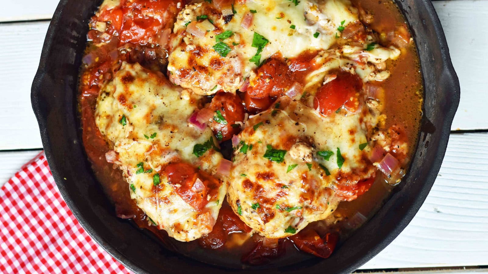Baked chicken topped with melted mozzarella, tomatoes, and basil.