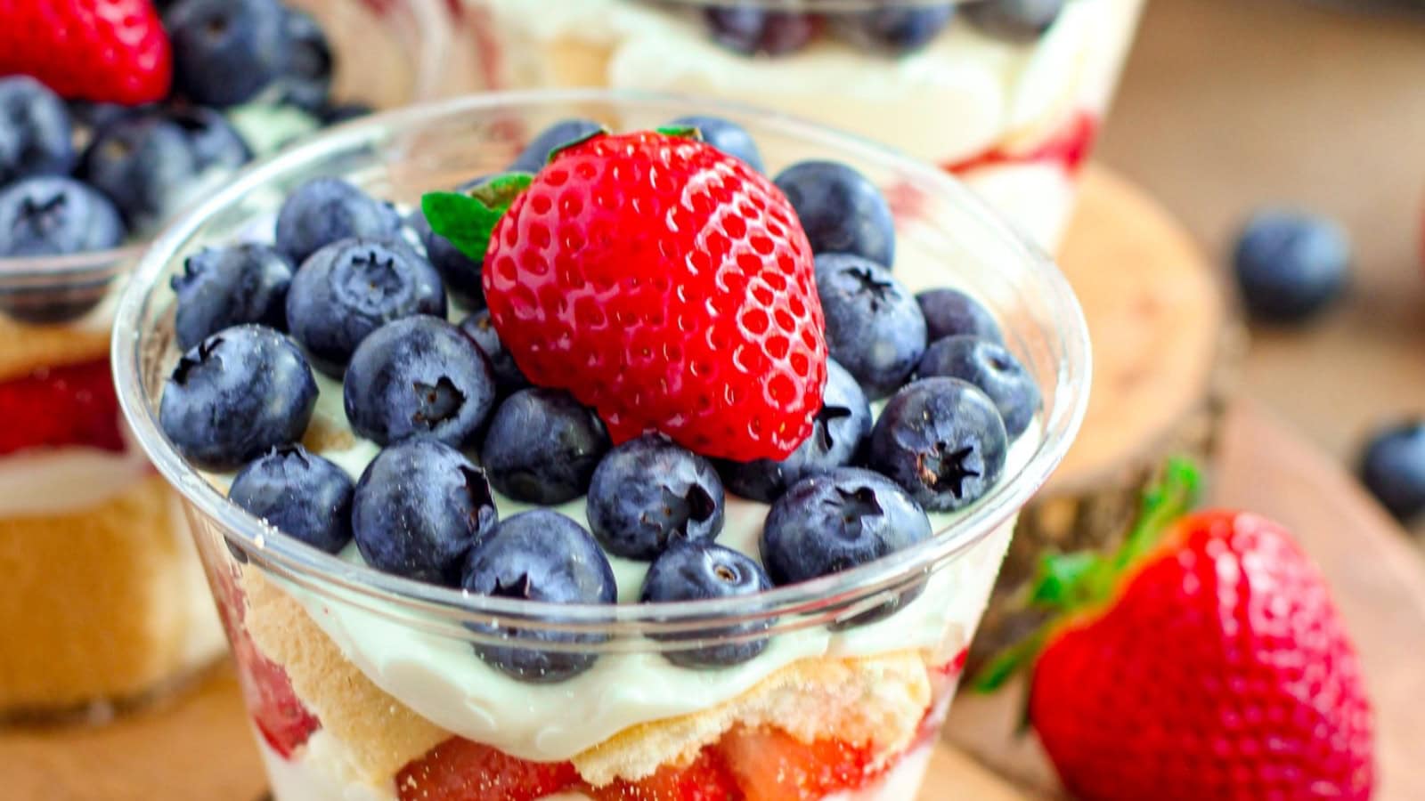 Individual berry trifles layered with cream and fresh fruit.