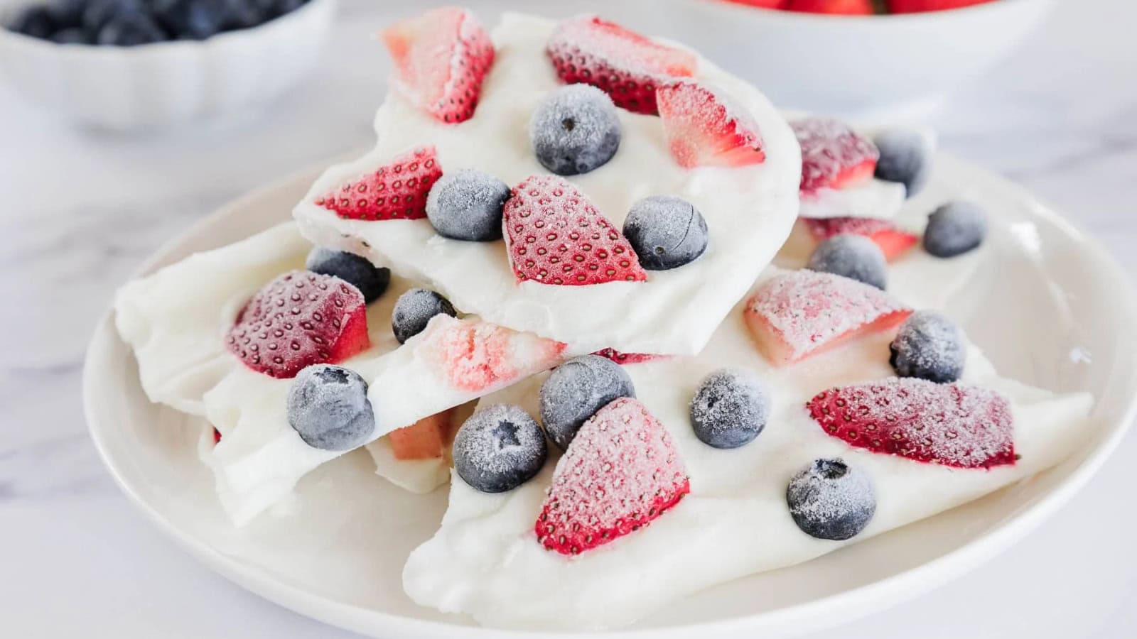 Frozen yogurt bark topped with mixed berries and crunchy toppings.