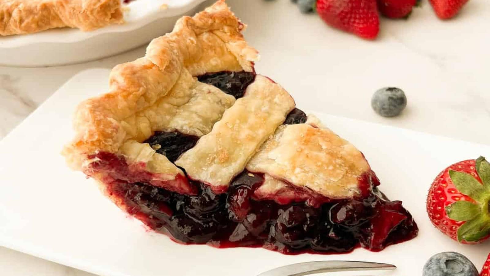 Fresh blueberry strawberry pie with a golden crust and berry filling.