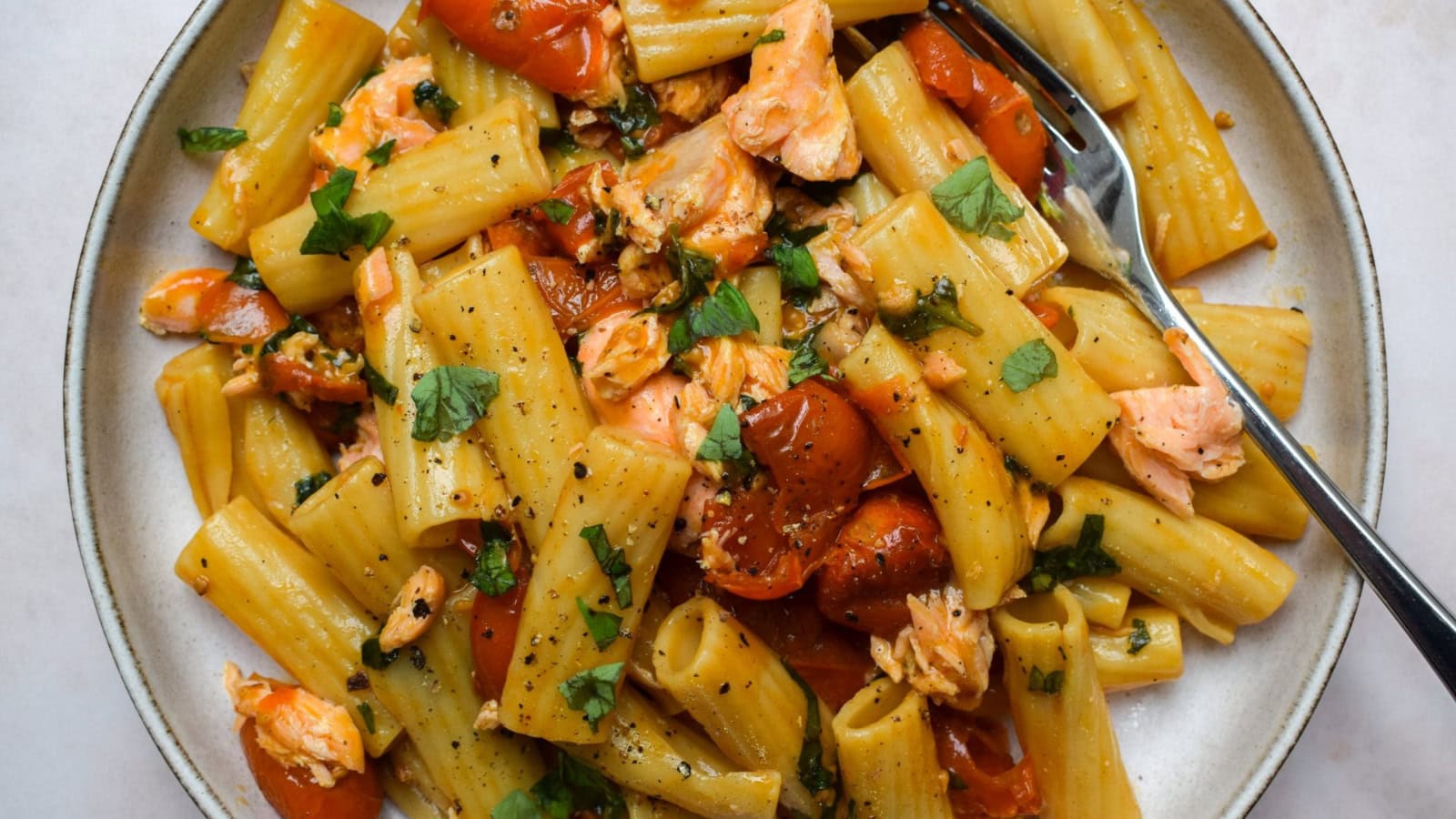 Salmon pasta tossed with butter-roasted cherry tomatoes and herbs.