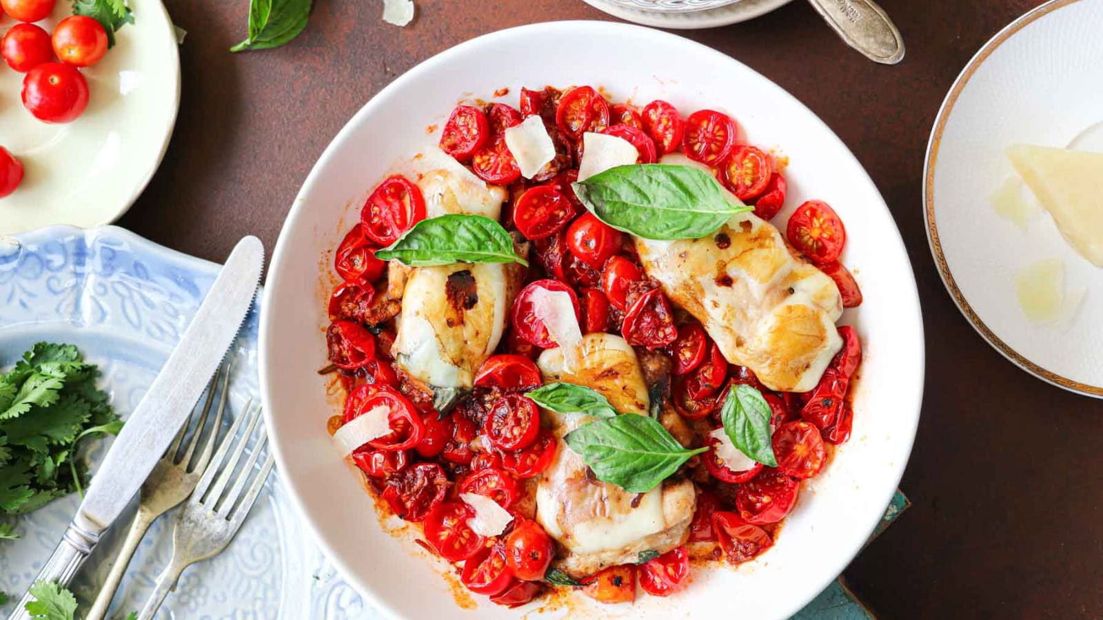 Chicken topped with mozzarella, tomatoes, and fresh basil leaves.
