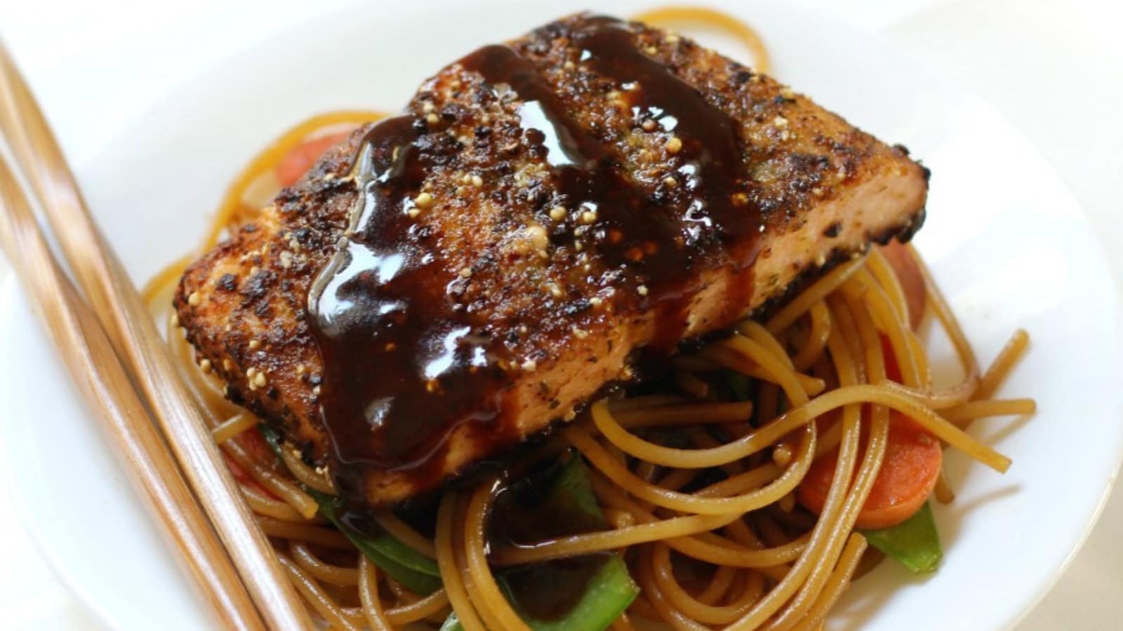 Salmon served with sticky garlic noodles and a citrus ginger glaze.