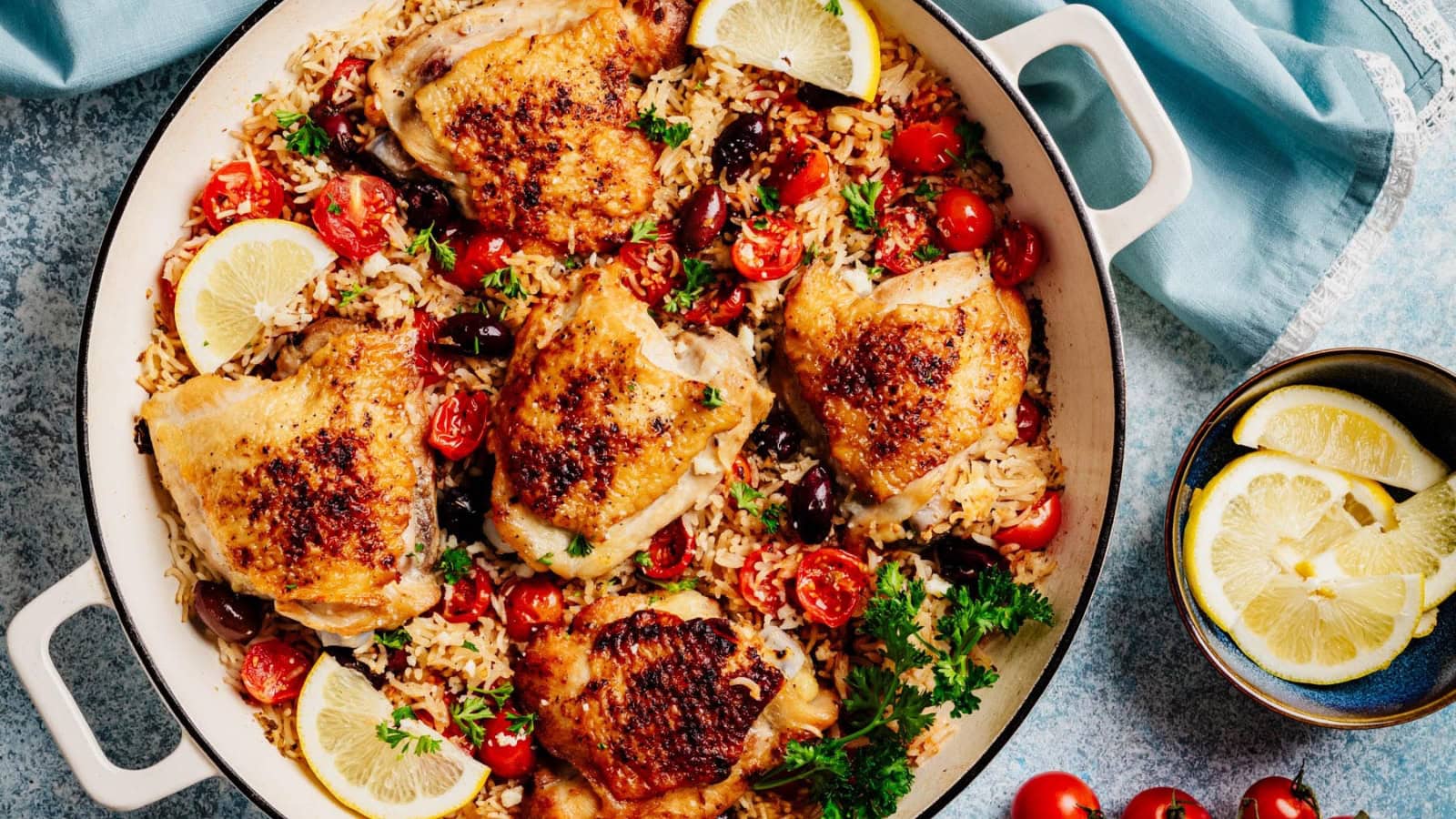 Greek-style chicken served with rice, tomatoes, and fresh herbs.