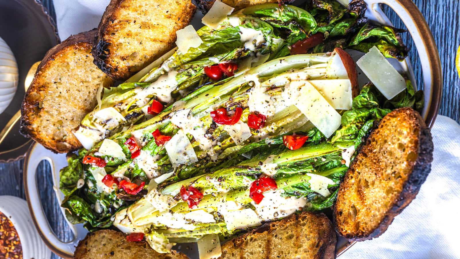 Caesar salad topped with grilled lettuce and creamy dressing.