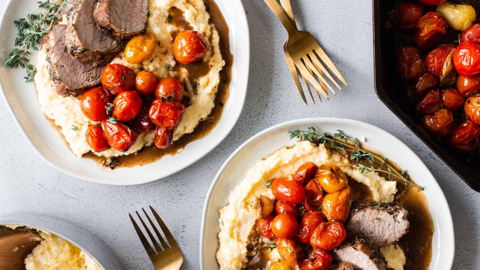 Herb-crusted pork tenderloin served with creamy polenta and tomatoes.