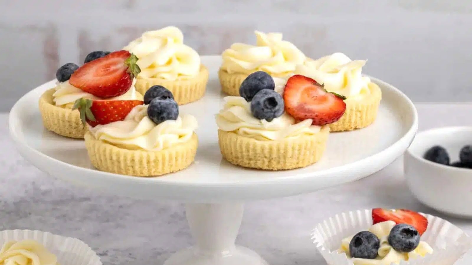 Sugar cookie cups filled with creamy cheesecake and fresh berries.