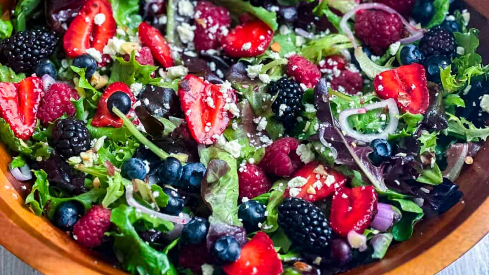 Berry salad mixed with fresh summer berries and greens.