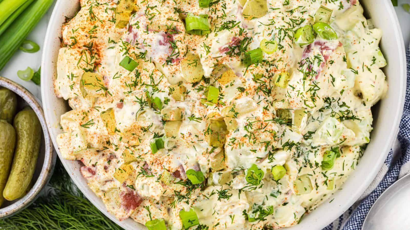 Potato salad mixed with dill pickles and creamy dressing.