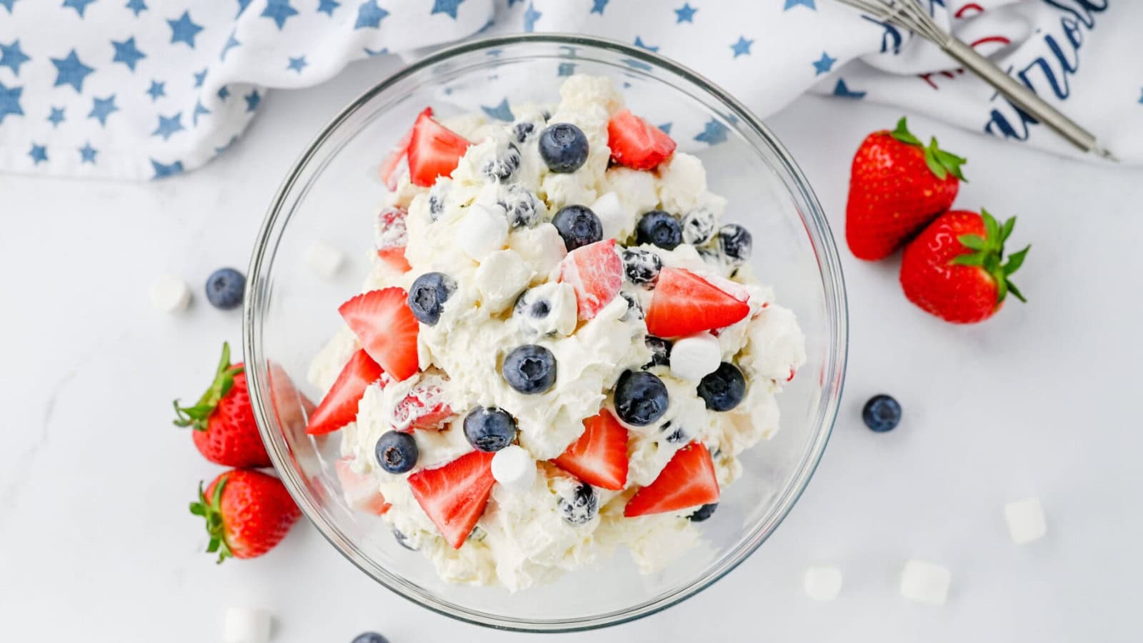 Cheesecake salad mixed with strawberries, blueberries, and creamy filling.