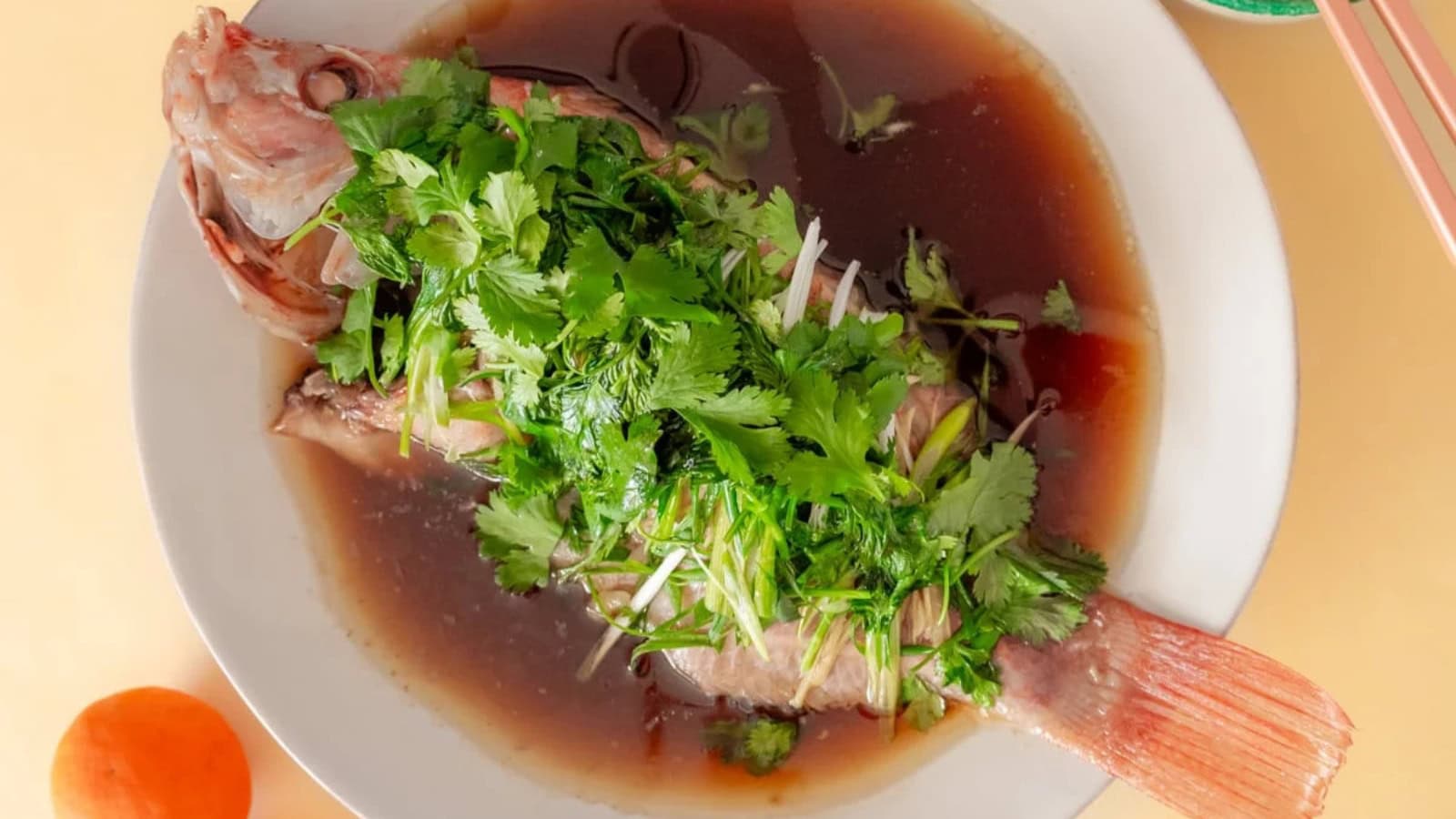 Whole steamed fish topped with ginger, scallions, and soy sauce.