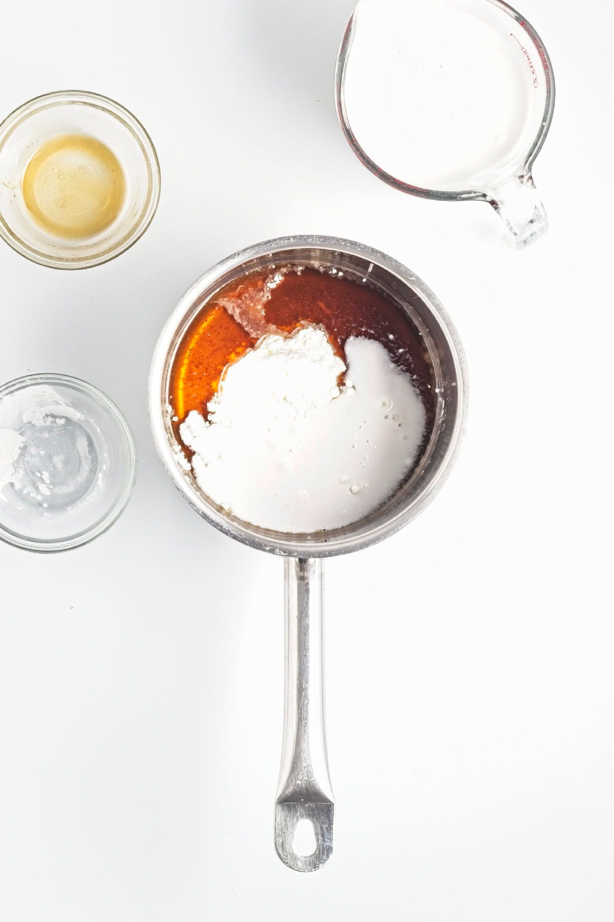 Coconut milk, maple syrup, and cornstarch added to a saucepan to make the strawberry popsicle base.