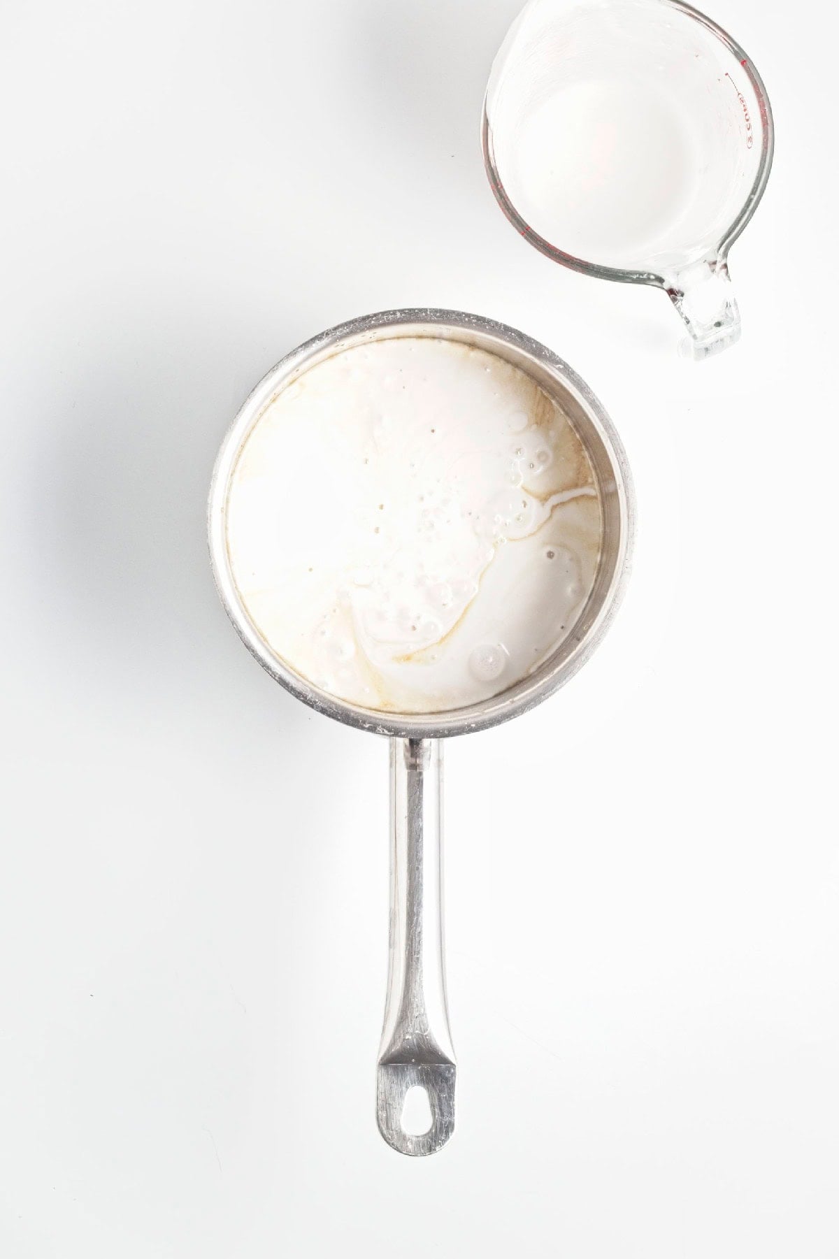 Creamy popsicle mixture cooking in a saucepan until smooth and slightly thickened.