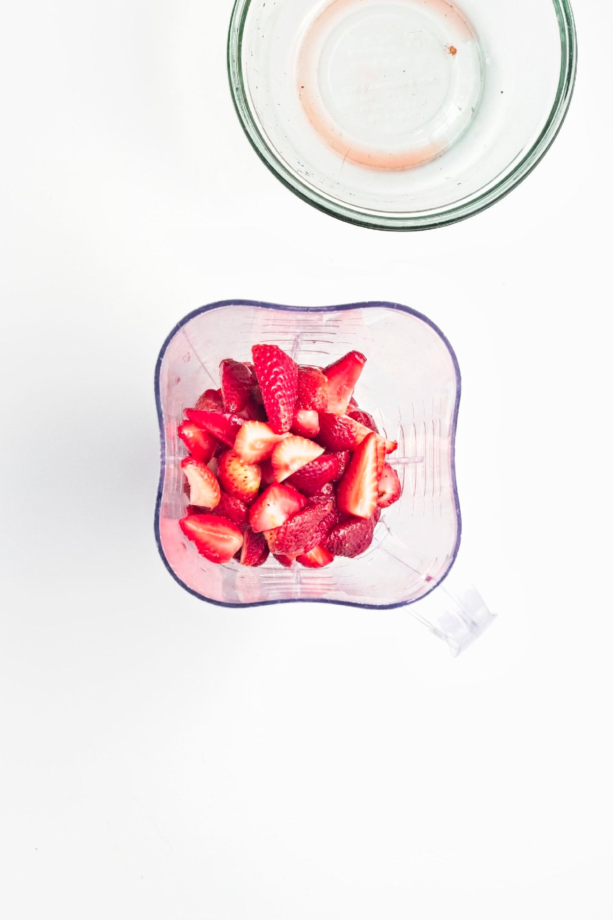 Smooth strawberry popsicle base cooling in a saucepan before combining with fruit.