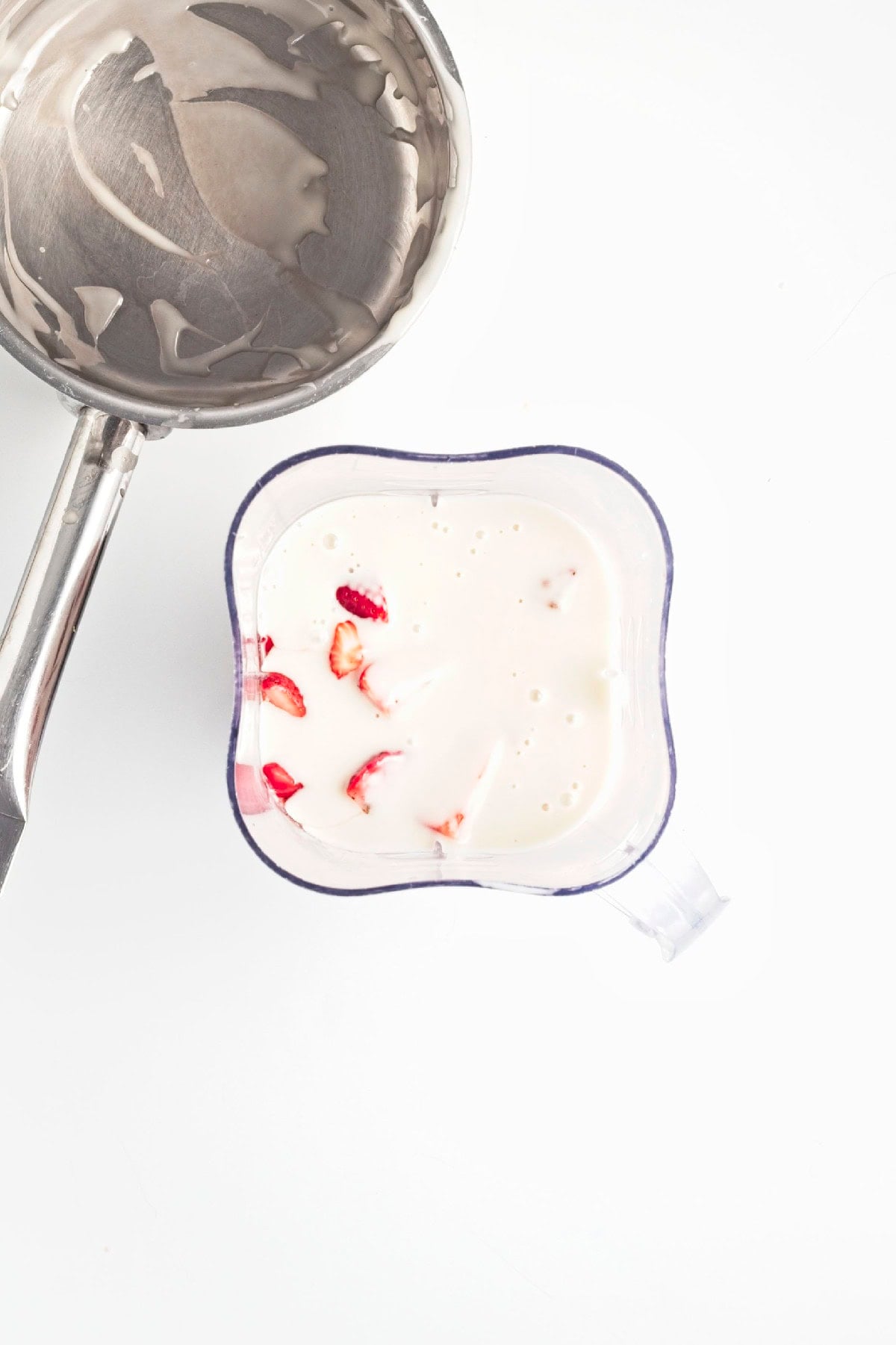 Fresh chopped strawberries added to a blender for homemade strawberry popsicles.