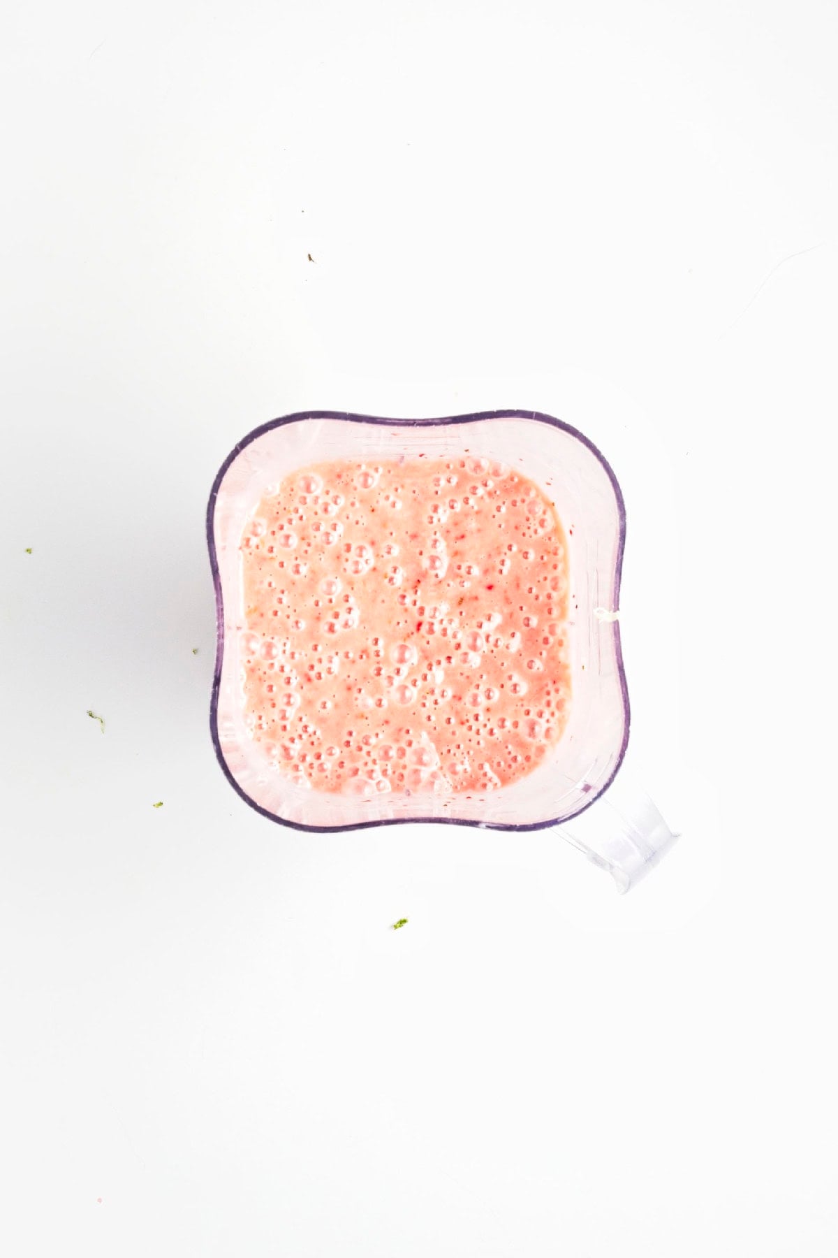 Fresh lime zest added to the strawberry popsicle mixture before blending.