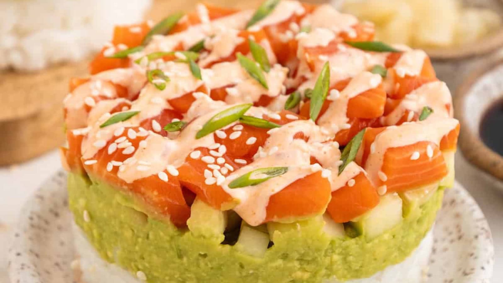 Layered sushi stacks with rice, seafood, avocado, and fresh toppings.