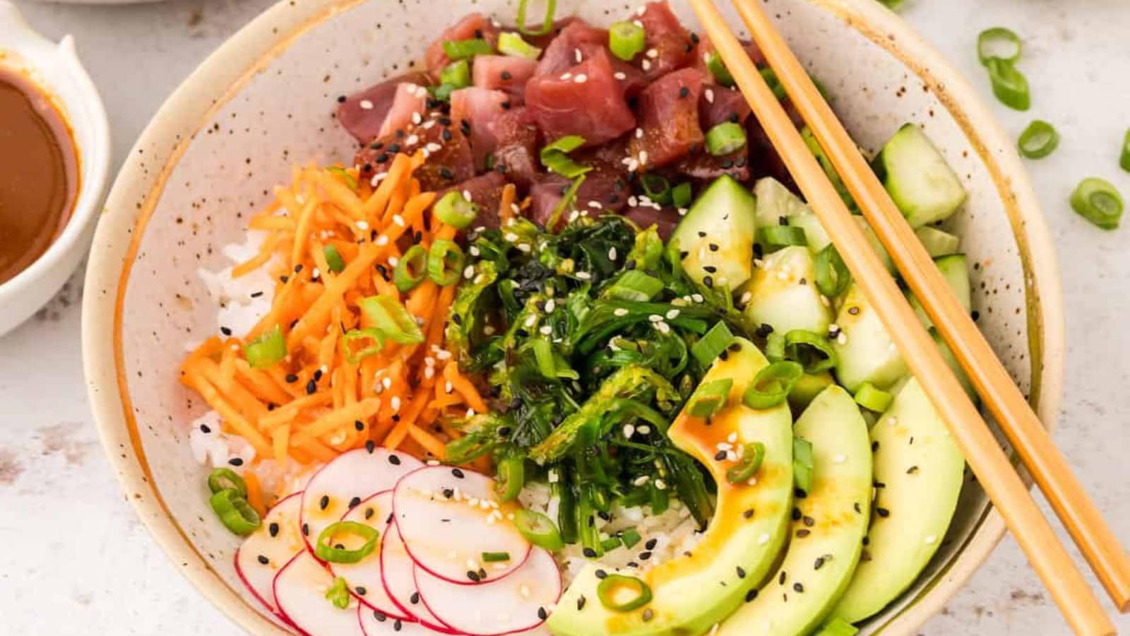 Tuna poke bowl with rice, fresh vegetables, and flavorful toppings.