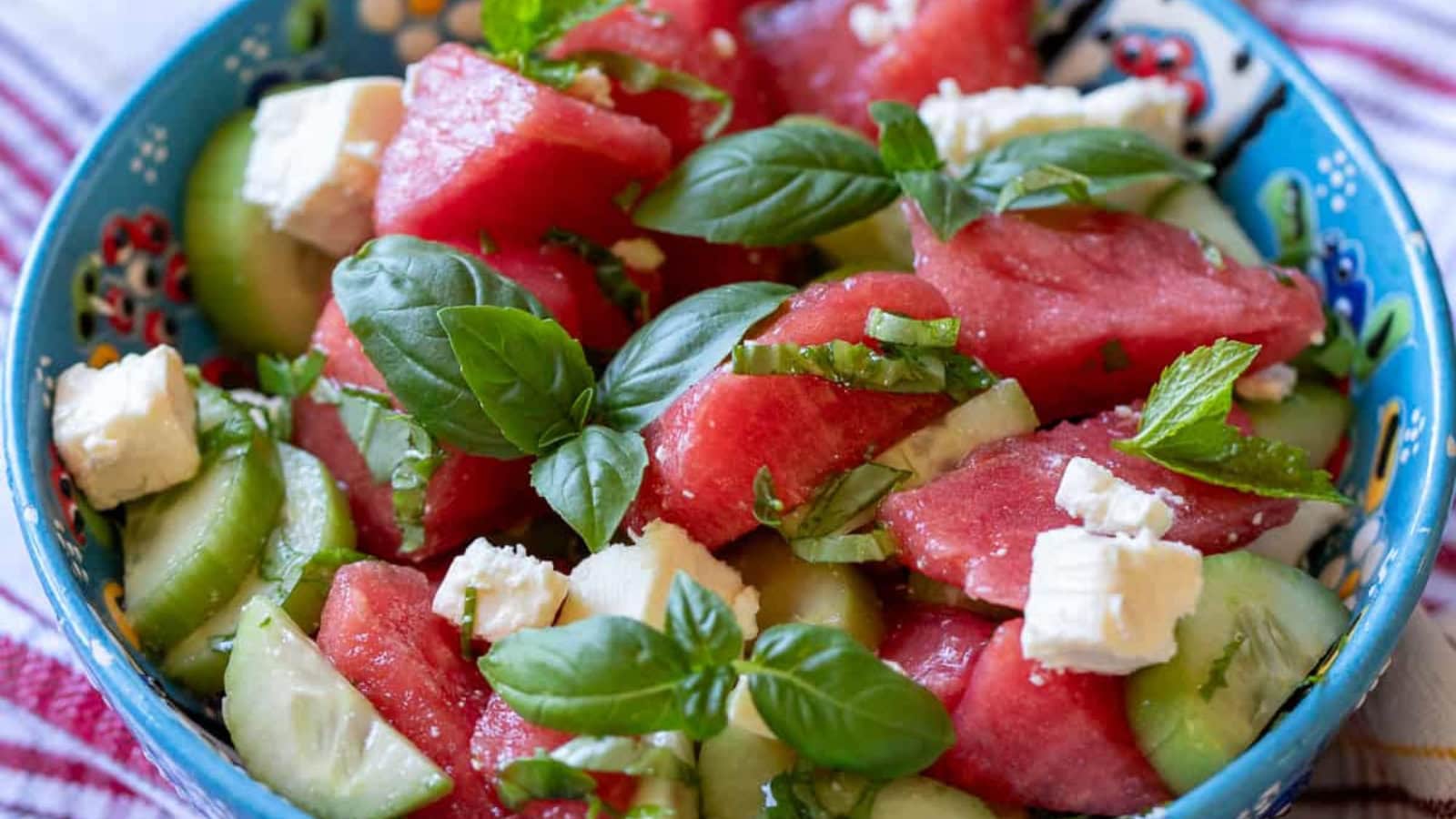 Watermelon salad mixed with feta, cucumber, and fresh basil.
