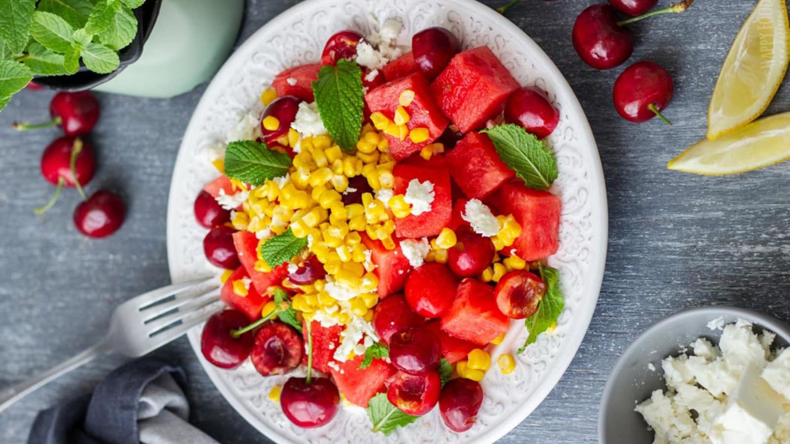 Watermelon salad mixed with cherries, feta cheese, and fresh herbs.