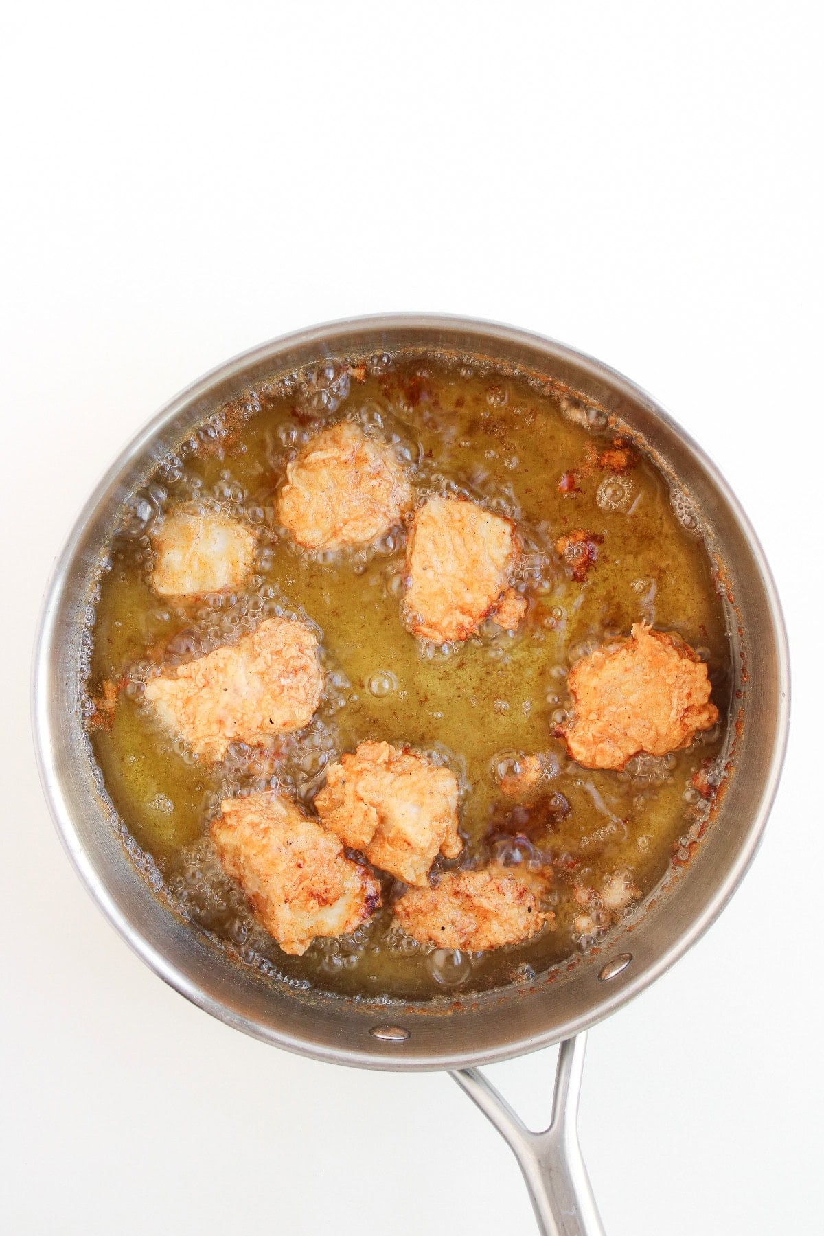 Golden brown boneless buffalo wings frying in hot oil.