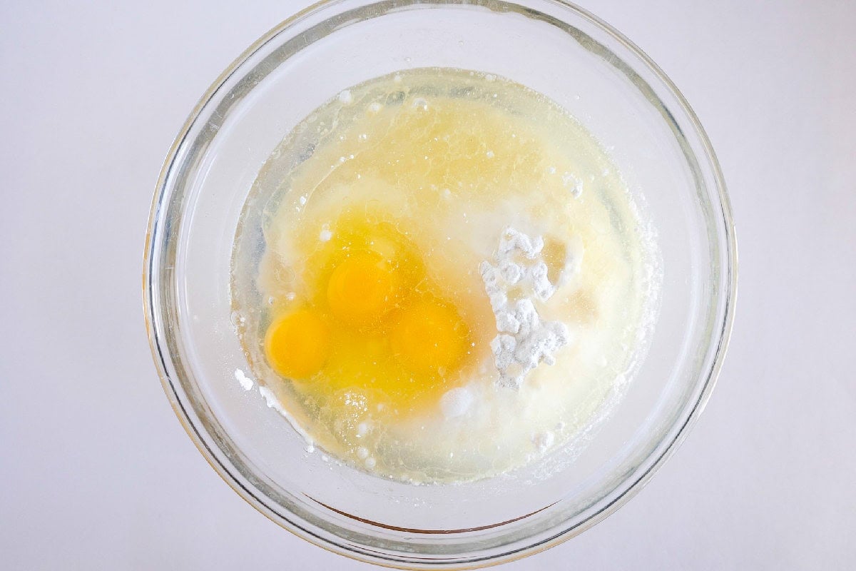 Cake mix, eggs, and oil combined in a glass mixing bowl before stirring.