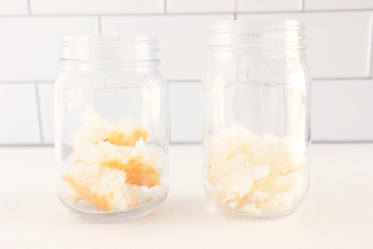 Angel food cake pieces layered in individual glass jars to start assembling red white and blue trifle.