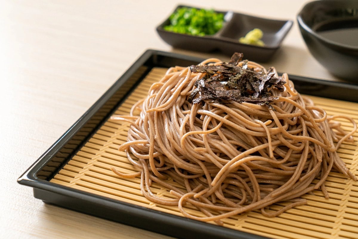 Cold Japanese soba noodles served on a bamboo tray with dipping sauce.