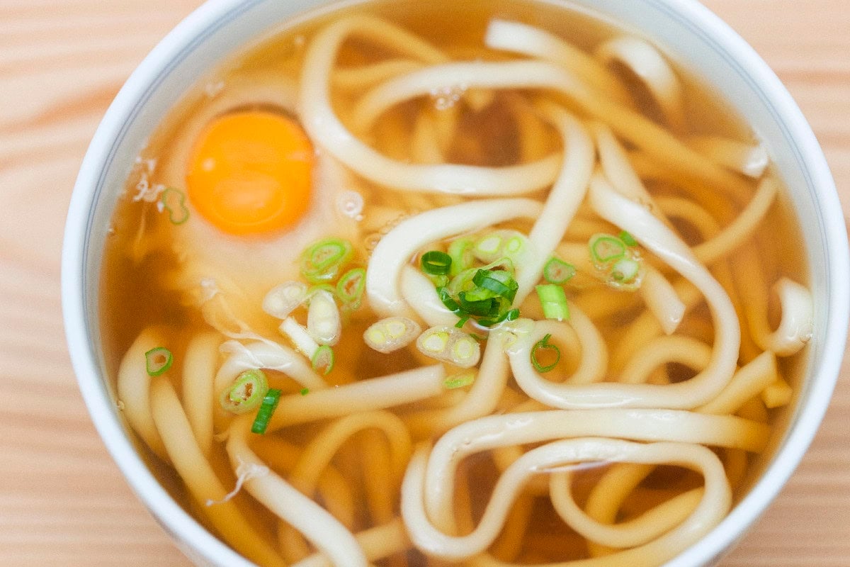 Japanese udon noodle soup with egg and green onions.