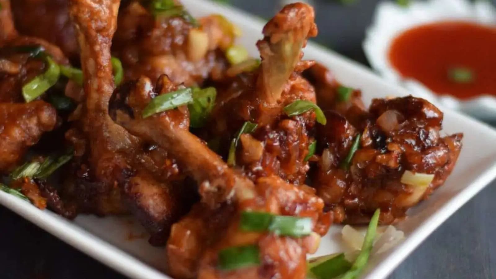 Chicken lollipops coated in a spicy, flavorful sauce.