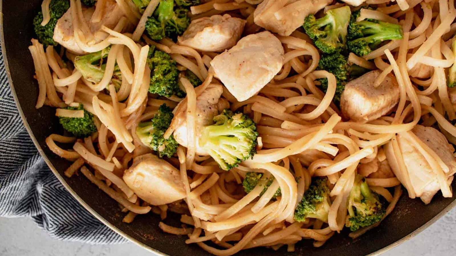 Rice noodles tossed with chicken, eggs, and fresh garnishes.
