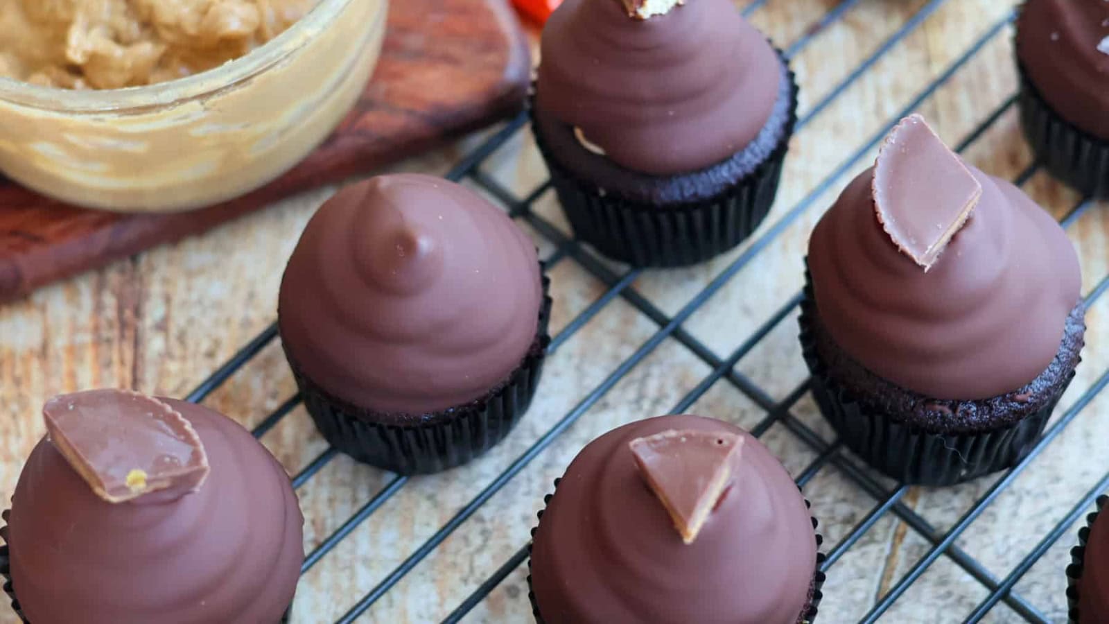 Chocolate cupcakes topped with peanut butter frosting and candy cups.