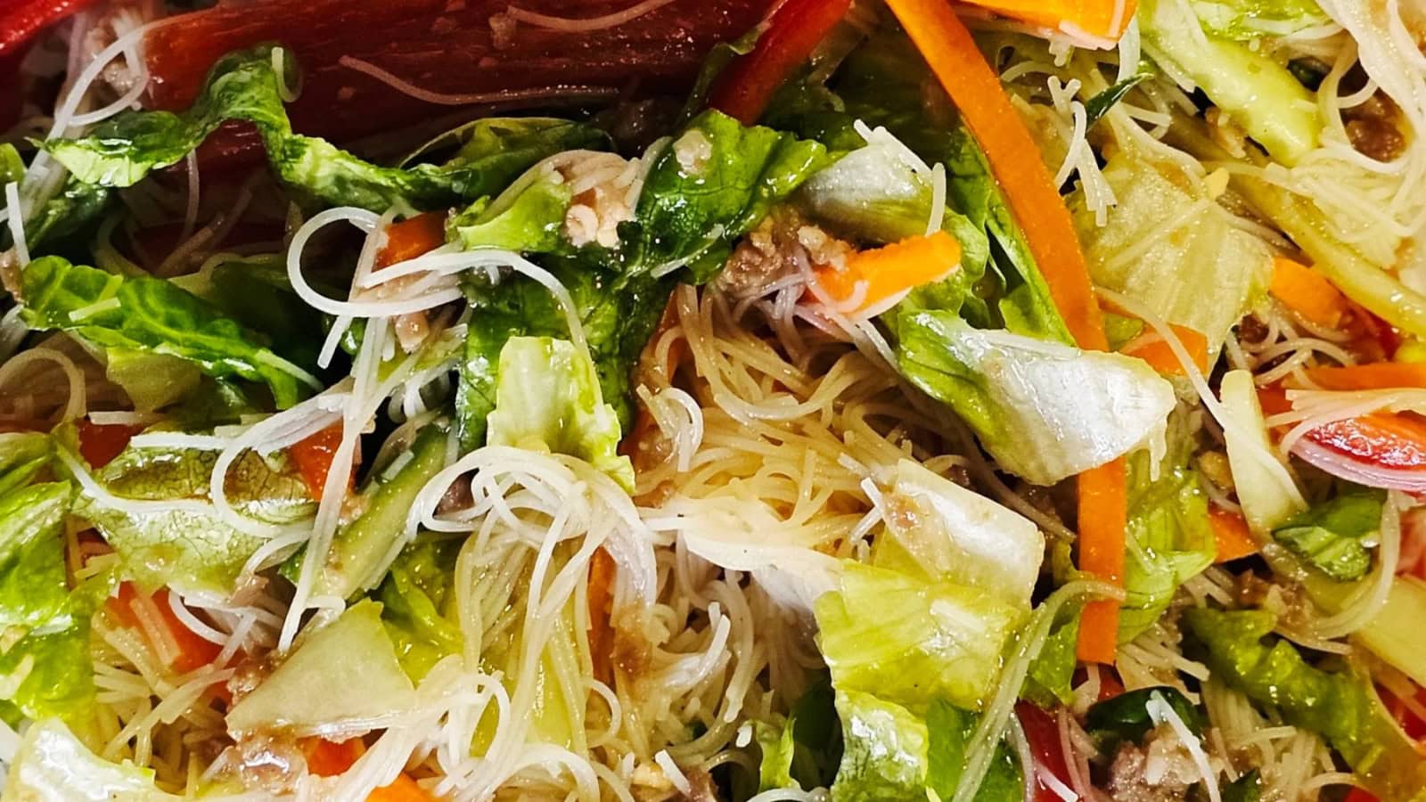 Crispy pork served over rice noodles with fresh vegetables and herbs.