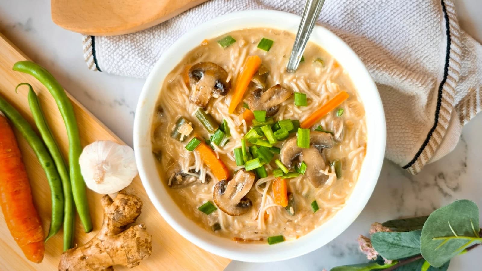 Vegetable noodle soup filled with colorful vegetables in a savory broth.