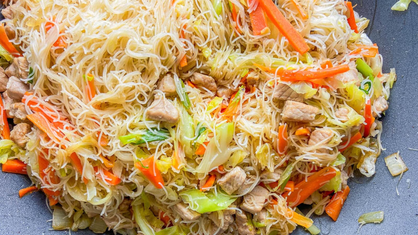 Filipino pancit made with stir-fried noodles, vegetables, and meat.