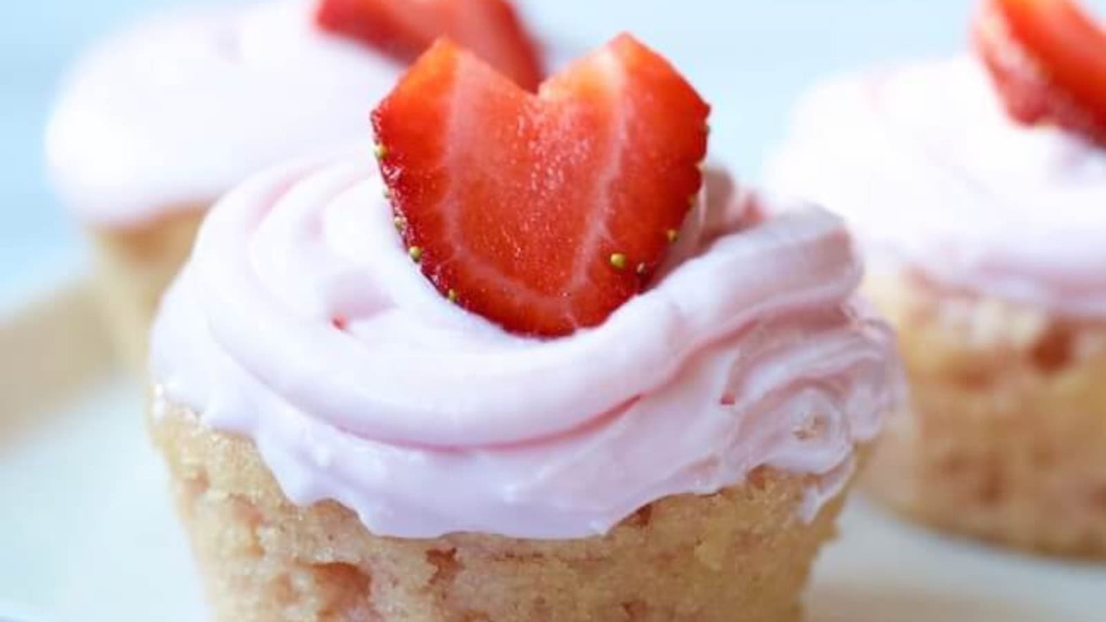 Gluten-free strawberry cupcakes topped with smooth strawberry frosting.