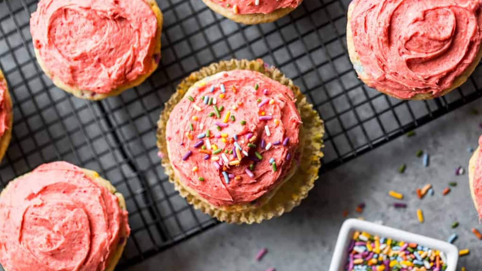 Funfetti cupcakes topped with creamy strawberry buttercream and colorful sprinkles.