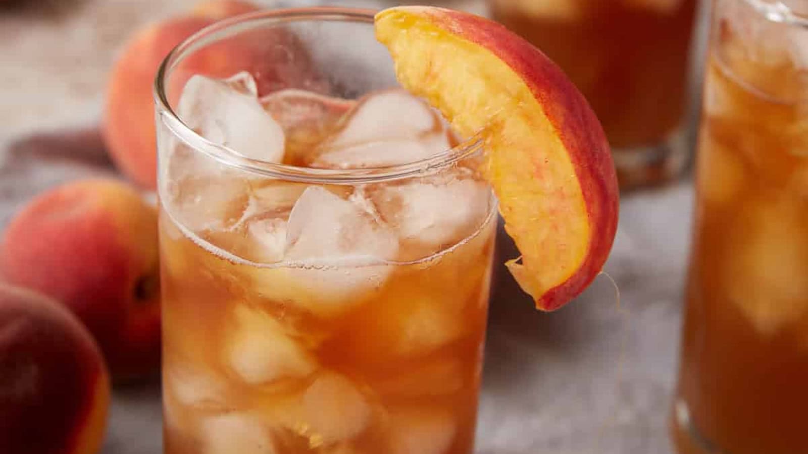 Chilled peach tea with fresh peach slices and ice.