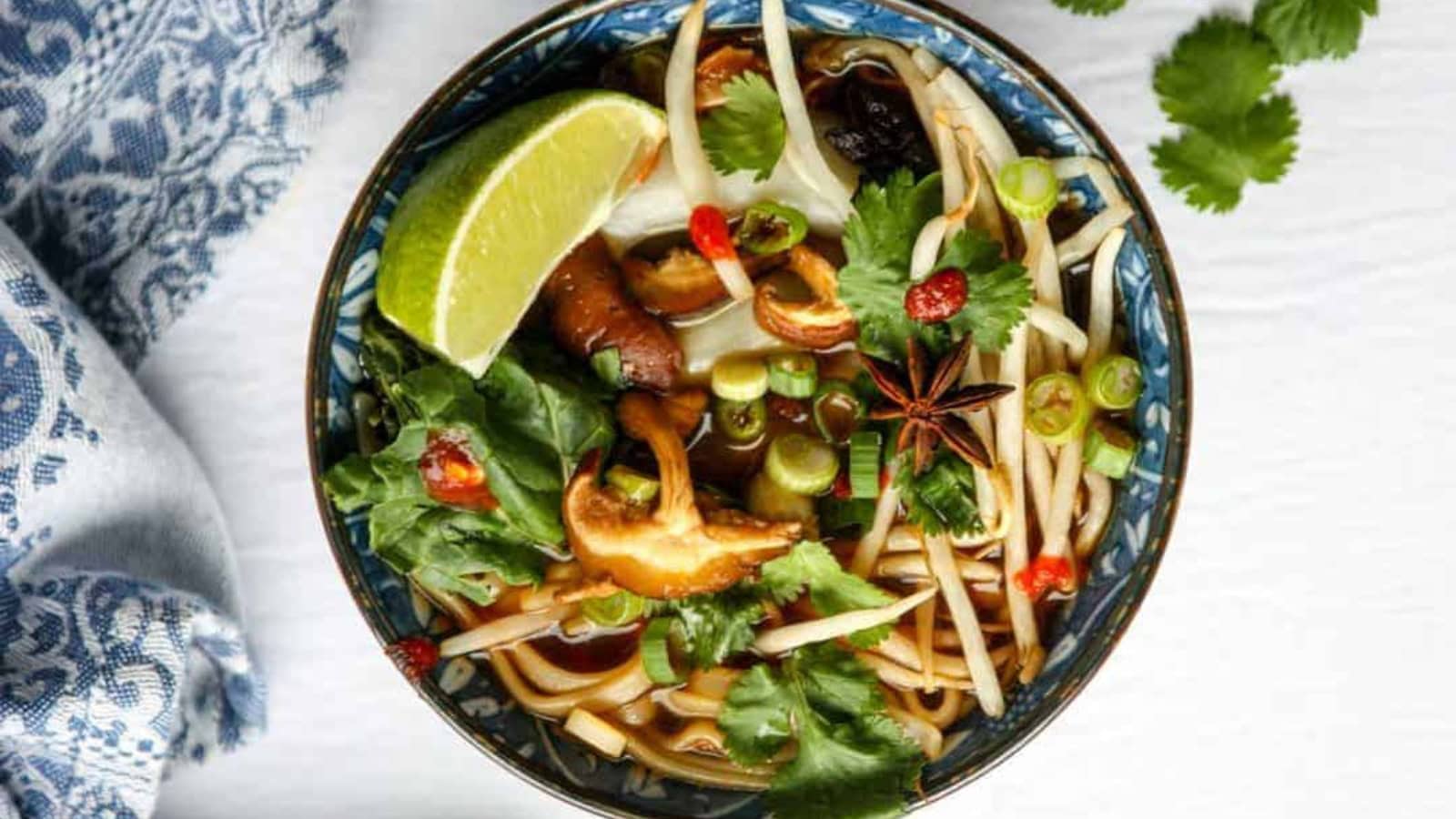 Vegan pho with rice noodles, vegetables, and aromatic broth.