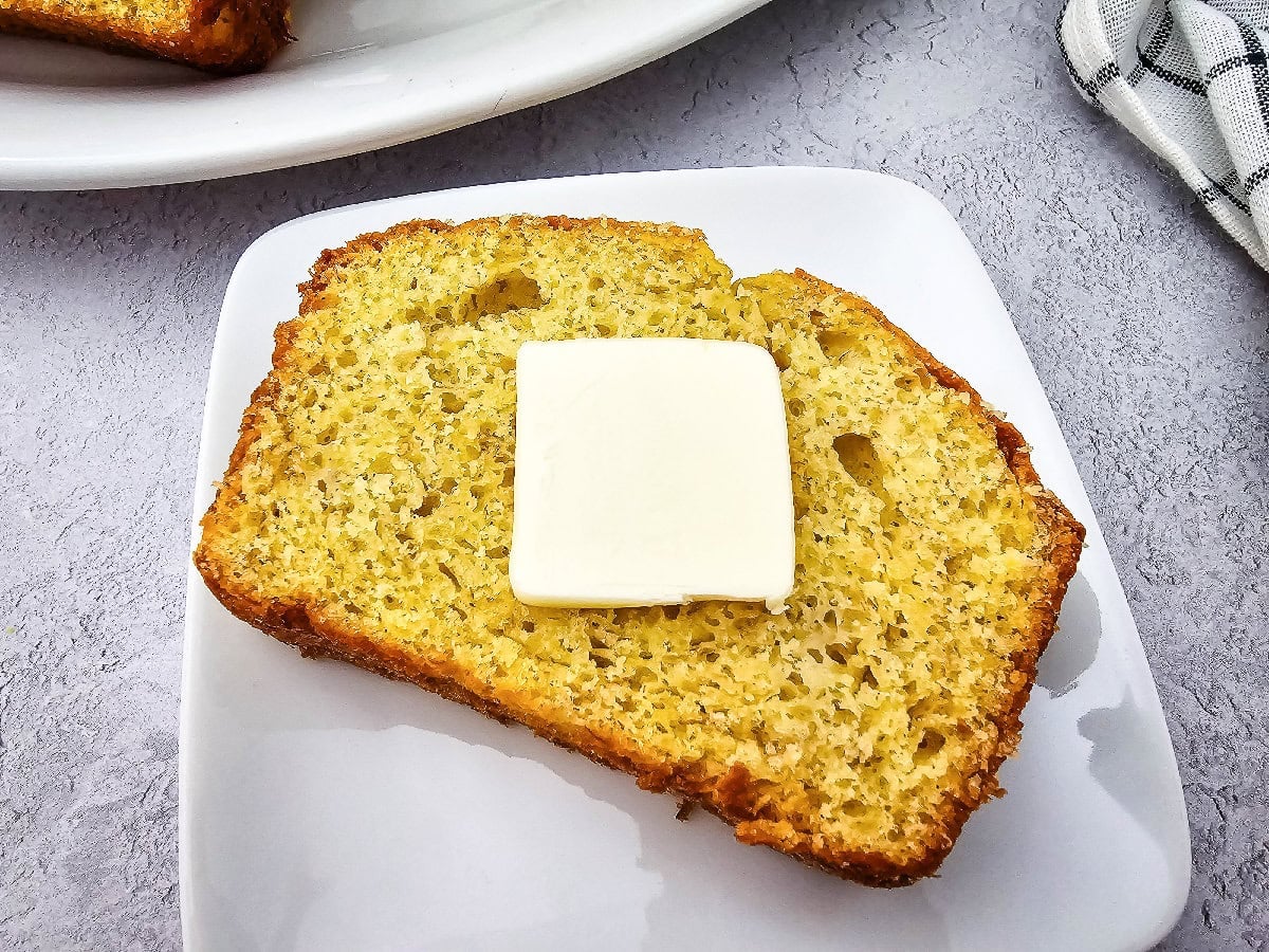 Slice of banana bread made with yellow cake mix topped with butter and ready to enjoy.