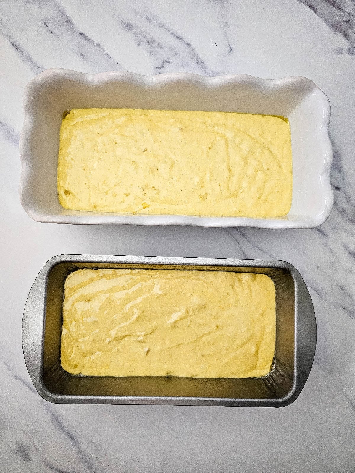 Banana bread batter poured into two loaf pans and ready to bake.