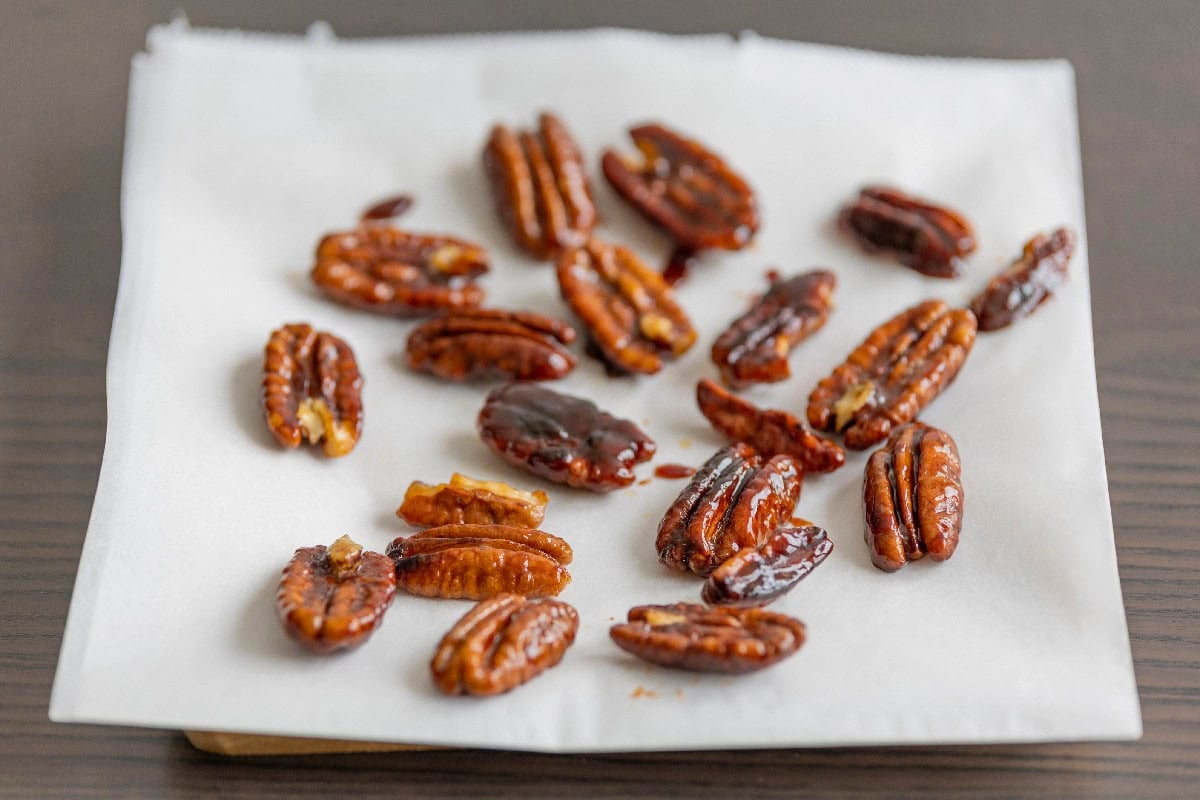 Toasted pecans cooling on parchment paper after roasting in the oven.
