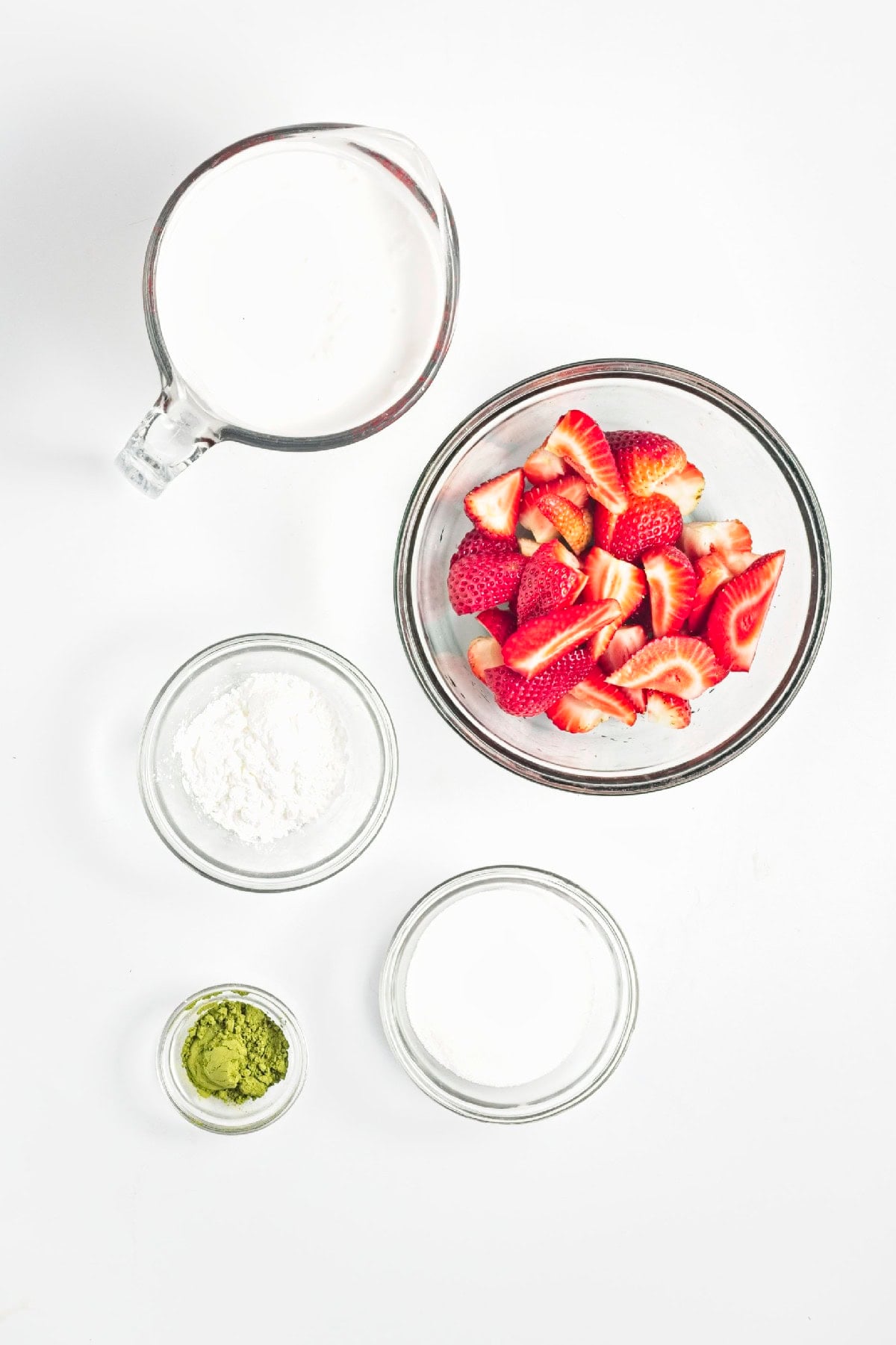 Ingredients for matcha popsicles, including strawberries, coconut milk, cornstarch, sugar, and matcha powder.