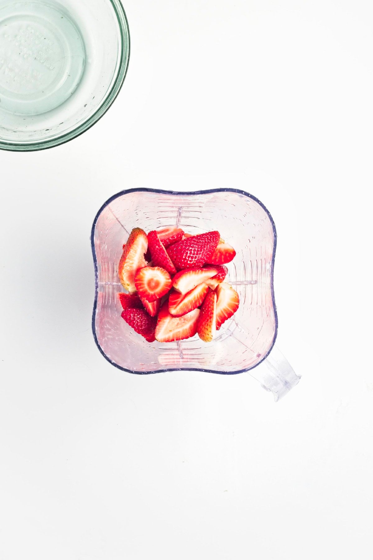 Fresh strawberries added to a blender before making the strawberry layer for matcha popsicles.