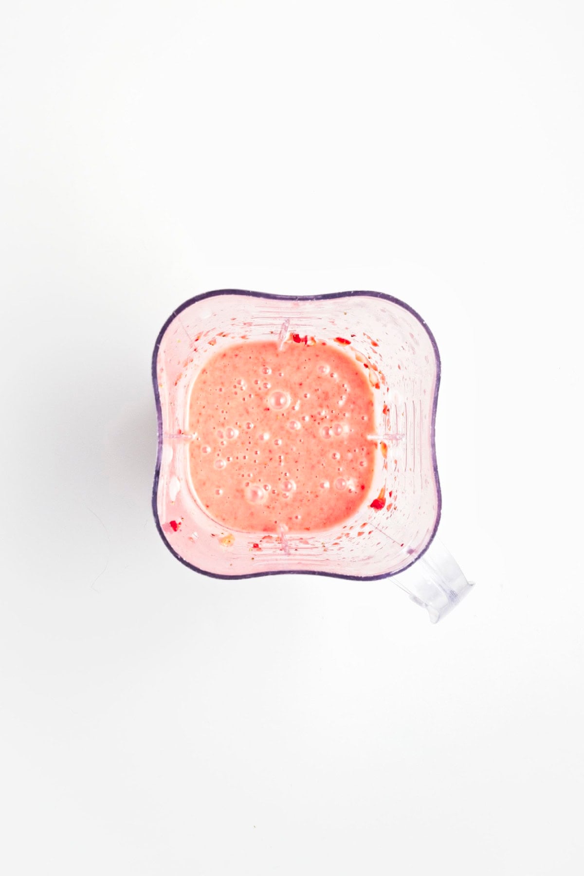 Creamy strawberry mixture blended until smooth for homemade popsicles.
