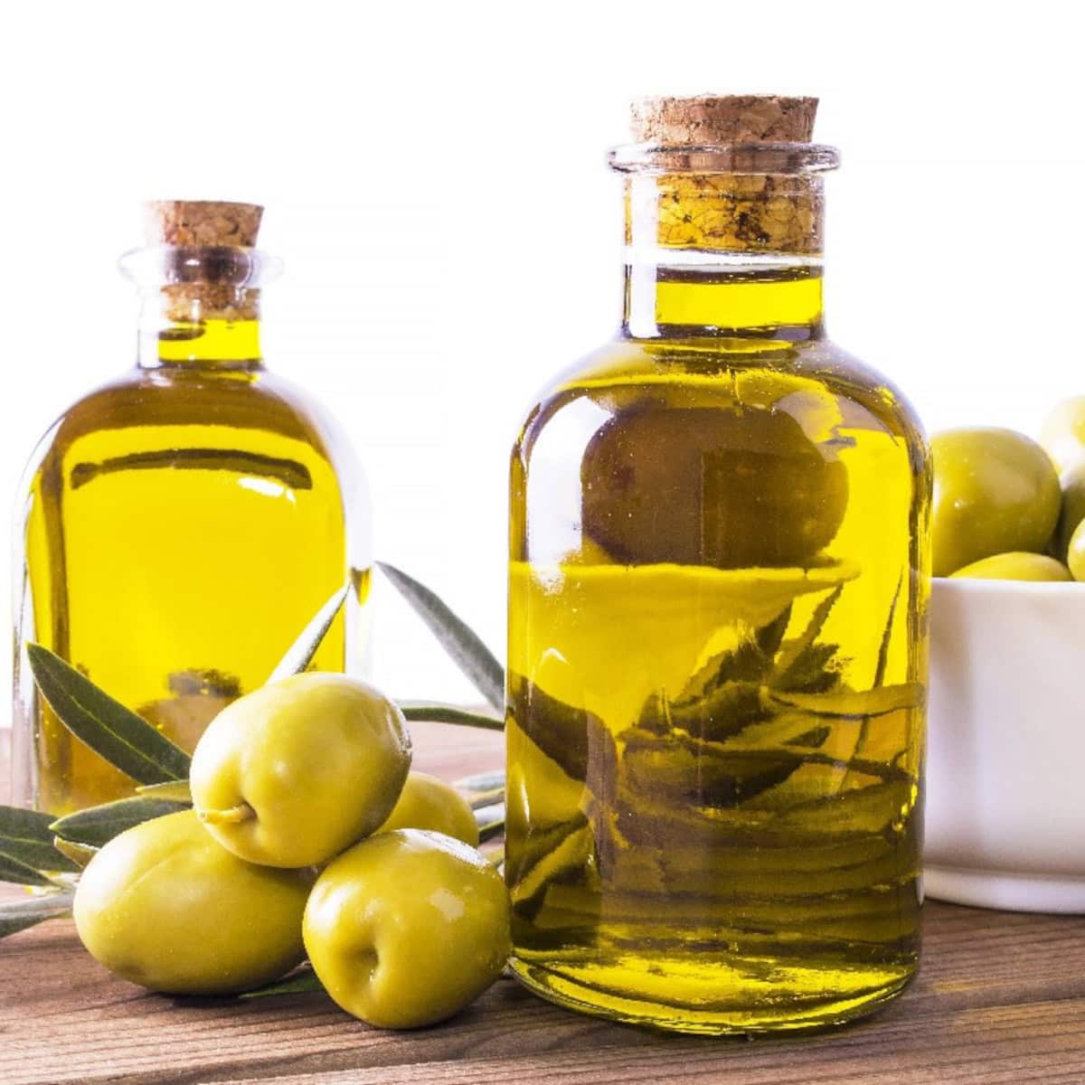 Extra virgin olive oil in bottles with fresh olives, a common sesame oil substitute.