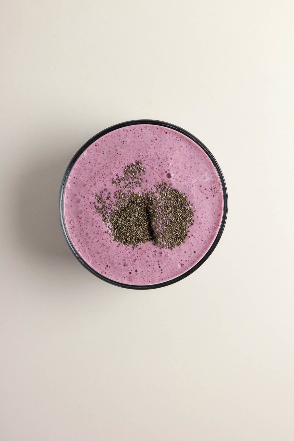 Chia seeds added to the blended berry mixture in a bowl.